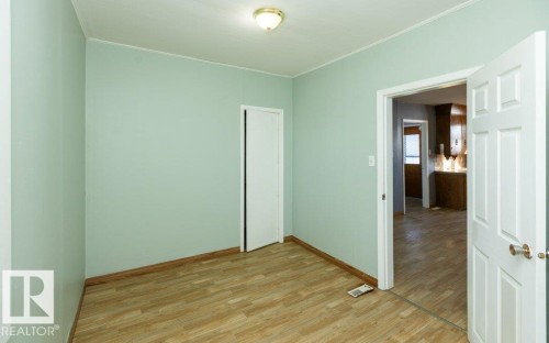 Room with light green walls and wood-finish flooring - 9836 100 Street, Westlock, AB 