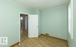 Interior room with light green walls and wood-finish flooring - 