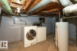 Dedicated laundry area featuring a front-load washer, a dryer unit, and a water heater - 
