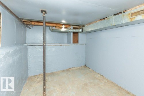 Concrete floor and painted foundation walls with exposed ceiling joists and ductwork - 9836 100 Street, Westlock, AB 