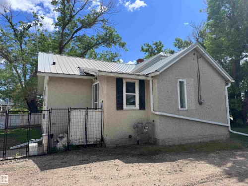 Stucco exterior with a metal roof and white gutters - 9836 100 Street, Westlock, AB 