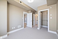 Spacious interior room featuring light beige wall paint, white trim, and light-colored carpeting - 