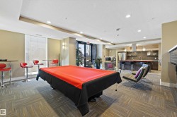 The Recreation Room has a modern kitchen featuring a striking red island countertop, stainless steel appliances, dark wood-finish cabinetry, and a dark subway tile backsplash, with a pool table and a lounge type seating to enjoy with your company. - 
