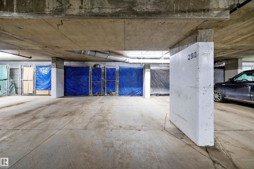 Underground parking area featuring concrete flooring and exposed concrete ceilings. Parking stall is right in front of the elevator. - 307 11080 Ellerslie Rd Sw, Edmonton, AB 