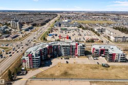 Modern multi-story residential buildings featuring contemporary architecture with vibrant red and gray facade panels. - 