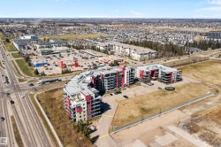 Modern multi-story residential buildings featuring contemporary architecture with vibrant red and gray facade panels. - 