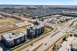 Modern multi-story residential buildings featuring contemporary architecture with vibrant red and gray facade panels. - 