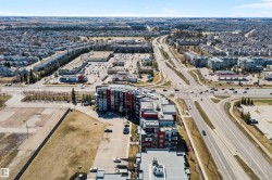 Modern multi-story residential buildings featuring contemporary architecture with vibrant red and gray facade panels. - 