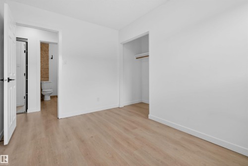 Light wood-finish flooring complements the bright white walls and trim - 7304/7306 78 Avenue, Edmonton, AB 