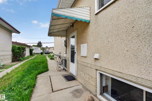 Side entry with a white door and an overhead awning - 7304/7306 78 Avenue, Edmonton, AB 