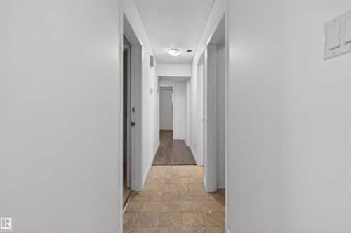 Corridor with light-colored walls and a textured ceiling - 7304/7306 78 Avenue, Edmonton, AB 