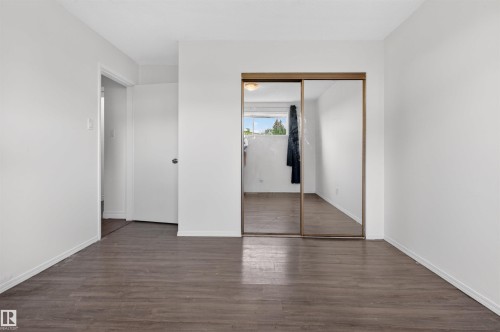 Room featuring wood-finish flooring, white painted walls, and white baseboards - 7304/7306 78 Avenue, Edmonton, AB 