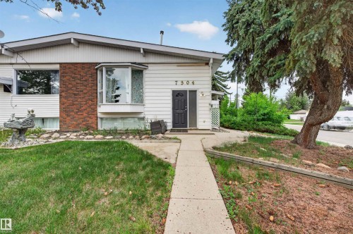 White siding exterior with brick accents and a bay window - 7304/7306 78 Avenue, Edmonton, AB 