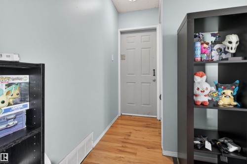 Light gray door with panel detailing, complemented by wood-finish flooring and light blue wall paint - 7304/7306 78 Avenue, Edmonton, AB 