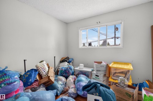 Hardwood-style flooring and light-toned walls define this interior space, featuring a multi-pane window - 7304/7306 78 Avenue, Edmonton, AB 