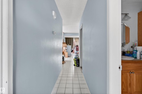 Hallway featuring light blue walls and white tile flooring - 7304/7306 78 Avenue, Edmonton, AB 