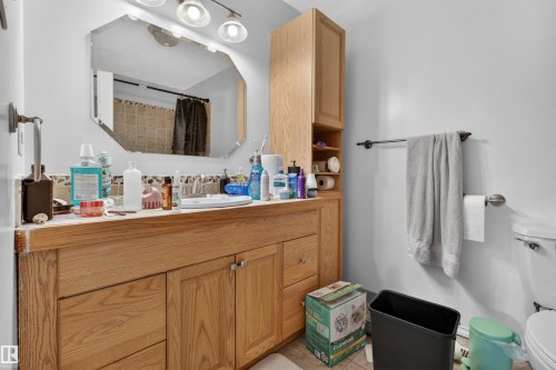 Wood-finish vanity with dual cabinet storage and an integrated sink - 7304/7306 78 Avenue, Edmonton, AB 