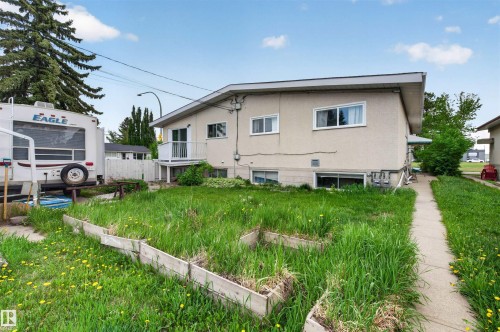 Rear exterior featuring a stucco finish, multiple windows, and a second-story balcony - 7304/7306 78 Avenue, Edmonton, AB 