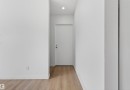 Hallway featuring light wood-finish flooring, white walls, and a recessed ceiling light - 7304/7306 78 Avenue, Edmonton, AB 
