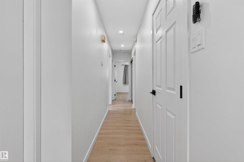 Bright hallway featuring light wood-finish flooring, white walls, and recessed lighting - 7304/7306 78 Avenue, Edmonton, AB 