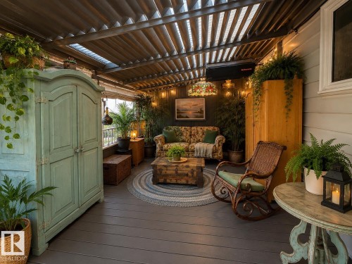 Covered outdoor patio featuring a slatted roof structure, dark gray wood-finish flooring, and light-colored siding - 10912 50 Street, Edmonton, AB 