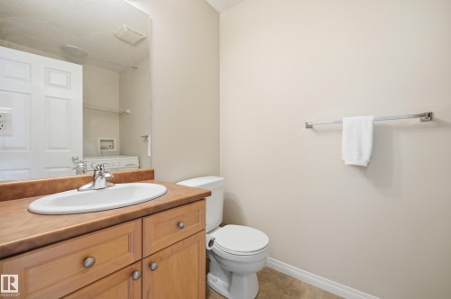 Bathroom vanity featuring a light wood cabinet with silver hardware, a brown countertop, and an oval sink with a chrome faucet - 11628 167A Avenue, Edmonton, AB - Indoor Photo Showing Bathroom