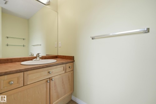 Vanity featuring light wood cabinetry, a built-in oval sink, and a brown countertop - 11628 167A Avenue, Edmonton, AB - Indoor Photo Showing Bathroom
