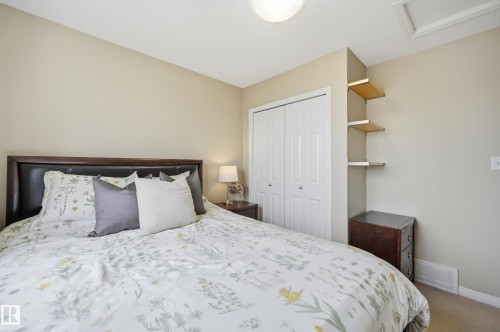 Bedroom featuring neutral wall paint, white bi-fold closet doors, and built-in shelving - 11628 167A Avenue, Edmonton, AB - Indoor Photo Showing Bedroom
