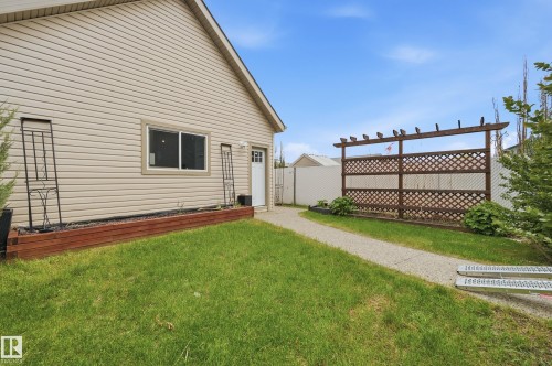 Exterior featuring light-colored siding, a white service door, and a horizontal window - 11628 167A Avenue, Edmonton, AB - Outdoor