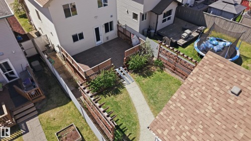 Spacious backyard featuring a concrete pathway, a wooden deck, and established perimeter fencing - 11628 167A Avenue, Edmonton, AB - Outdoor