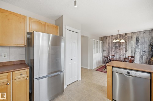 Open-concept kitchen and dining area featuring light wood cabinetry, stainless steel appliances, and tile flooring - 11628 167A Avenue, Edmonton, AB - Indoor Photo Showing Kitchen