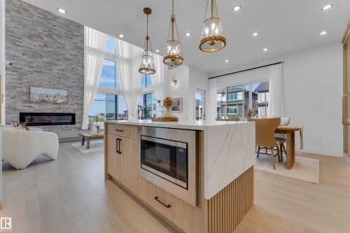 Kitchen island featuring a waterfall countertop with integrated microwave - 206 Linden Loop, Leduc, AB 