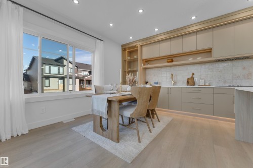 Open-concept dining area featuring light wood-finish flooring, a large multi-pane window, and recessed ceiling lighting - 206 Linden Loop, Leduc, AB 