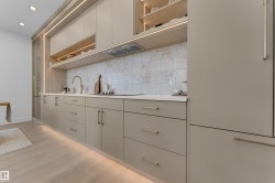 Kitchen featuring light wood-finish flooring and integrated under-cabinet lighting - 