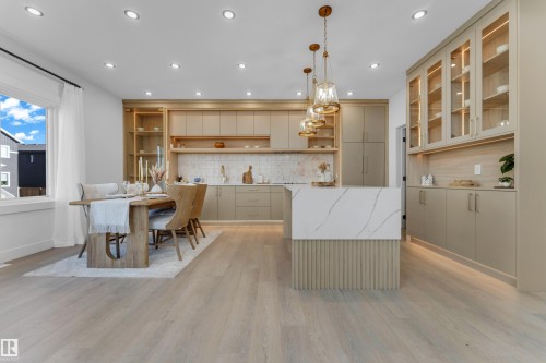 Open-concept kitchen and dining area featuring light wood-finish flooring - 206 Linden Loop, Leduc, AB 