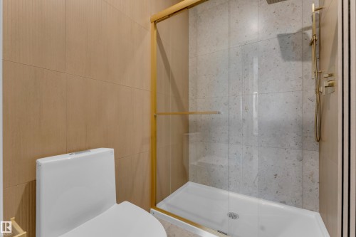 Shower enclosure with gold-toned framing, full glass panel, rainfall shower head, and handheld shower wand - 206 Linden Loop, Leduc, AB 