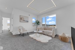Spacious upper-level area featuring plush gray carpeting, large windows, and contemporary recessed lighting - 