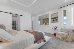 Carpeted room featuring recessed lighting, a sliding barn door, an interior window, and two exterior windows - 