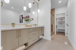 Dual vanity with white countertops and undermount sinks, complemented by gold-finish faucets and hardware - 