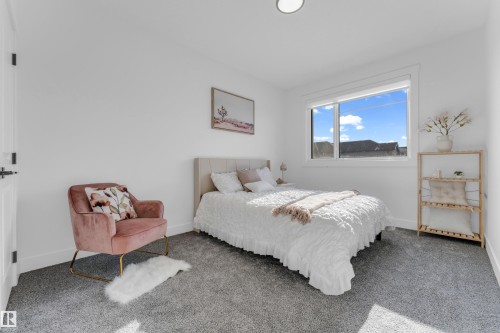 Carpeted room featuring a large window, white walls, and a ceiling-mounted light fixture - 206 Linden Loop, Leduc, AB 