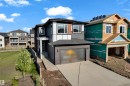 Contemporary exterior with dark siding accents, a two-car garage, and a concrete driveway - 206 Linden Loop, Leduc, AB 