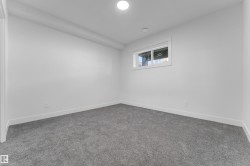 Carpeted room featuring a single window, white walls, white baseboards, and a circular ceiling light fixture - 