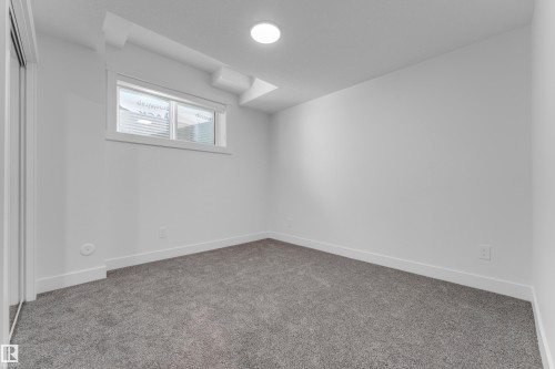 Interior space featuring wall-to-wall gray carpeting, white walls, and white baseboards - 206 Linden Loop, Leduc, AB 
