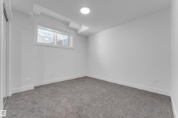 Interior space featuring wall-to-wall gray carpeting, white walls, and white baseboards - 