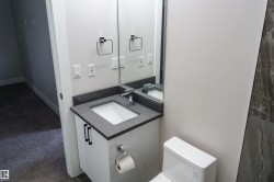Modern bathroom vanity featuring a dark speckled countertop, undermount sink, and contemporary faucet - 