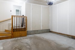 Spacious garage with concrete flooring and unfinished drywall walls - 