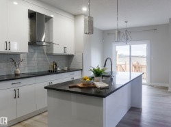 Modern kitchen featuring an expansive center island with an integrated sink and gooseneck faucet - 