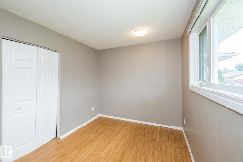 Room featuring wood-finish flooring, neutral wall tones, and white trim - 7543 149A Avenue, Edmonton, AB 