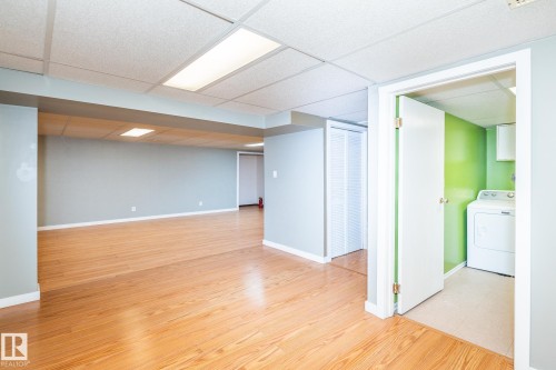 Lower level featuring wood-finish flooring, drop ceiling with integrated lighting, and neutral wall tones - 7543 149A Avenue, Edmonton, AB 