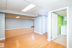 Lower level featuring wood-finish flooring, drop ceiling with integrated lighting, and neutral wall tones - 